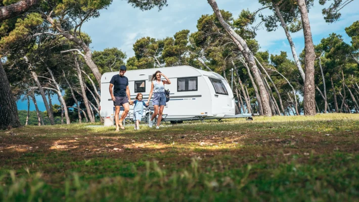 Familie på vei til campingvogn – ferie med barn og campingliv.